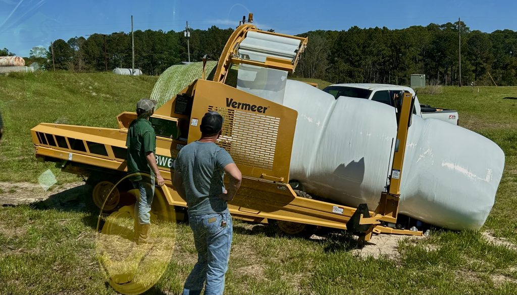 Photo of a Vermeer BW600 inline bale wrapper, a large yellow machine that wraps round hay bales in plastic.