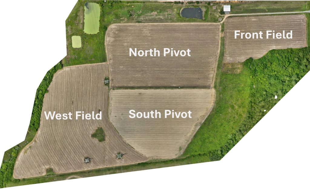 Drone image of the 4D DATA Farm, showing the four fields. On the left is the West Field, which abuts the North and South Pivot fields along its right edge. In the center of the image are the fields North Pivot and South Pivot, stacked on top of each other. On the top right corner of the photo is the Front Field, which connects along its left edge to the North Pivot. All of the fields are a light brown, indicating there is little to no plant growth.